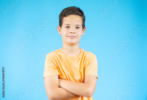 Portrait of happy beautiful little boy over blue background