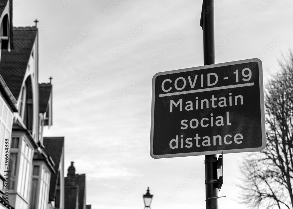 Obraz premium Solihull, United Kingdom - December 1 2020: Covid-19 'Maintain Social Distance' signpost after UK government announce tier system