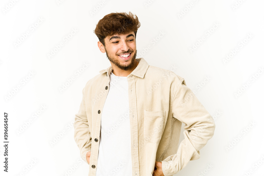 Young arab man on white background laughs happily and has fun keeping hands on stomach. Young arab man on white background laughs happily and has fun keeping hands on stomach.