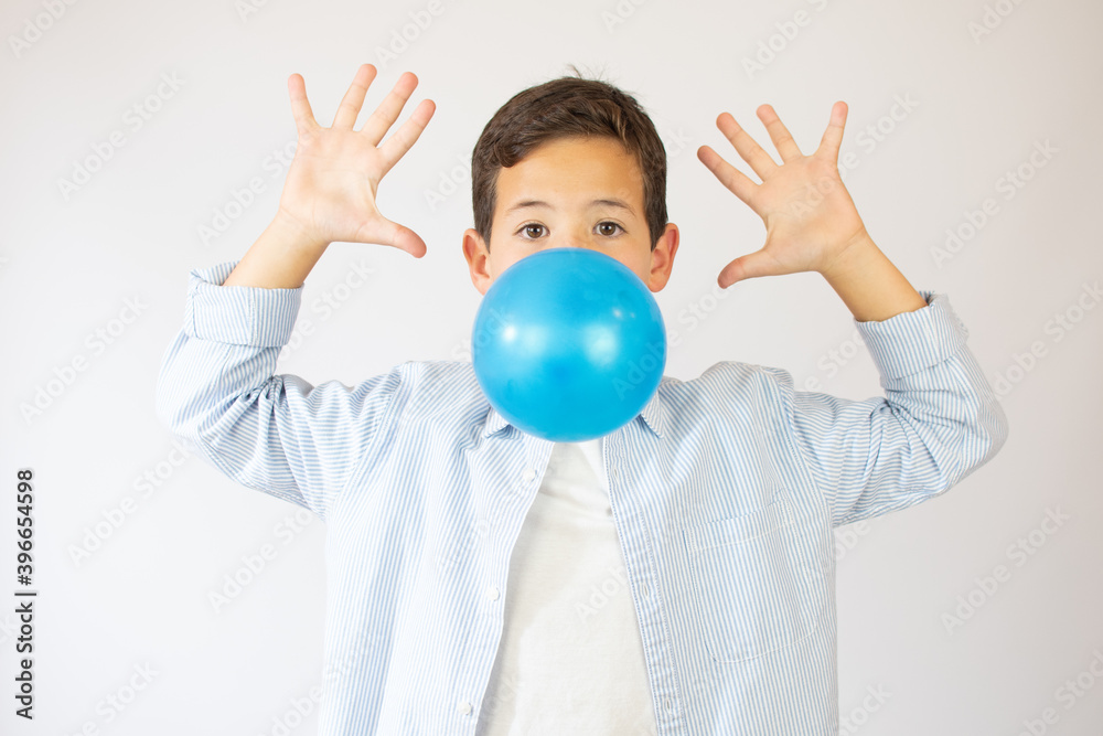 Funny boy blowing up a blue balloon isolated on white background Funny boy blowing up a blue balloon isolated on white background