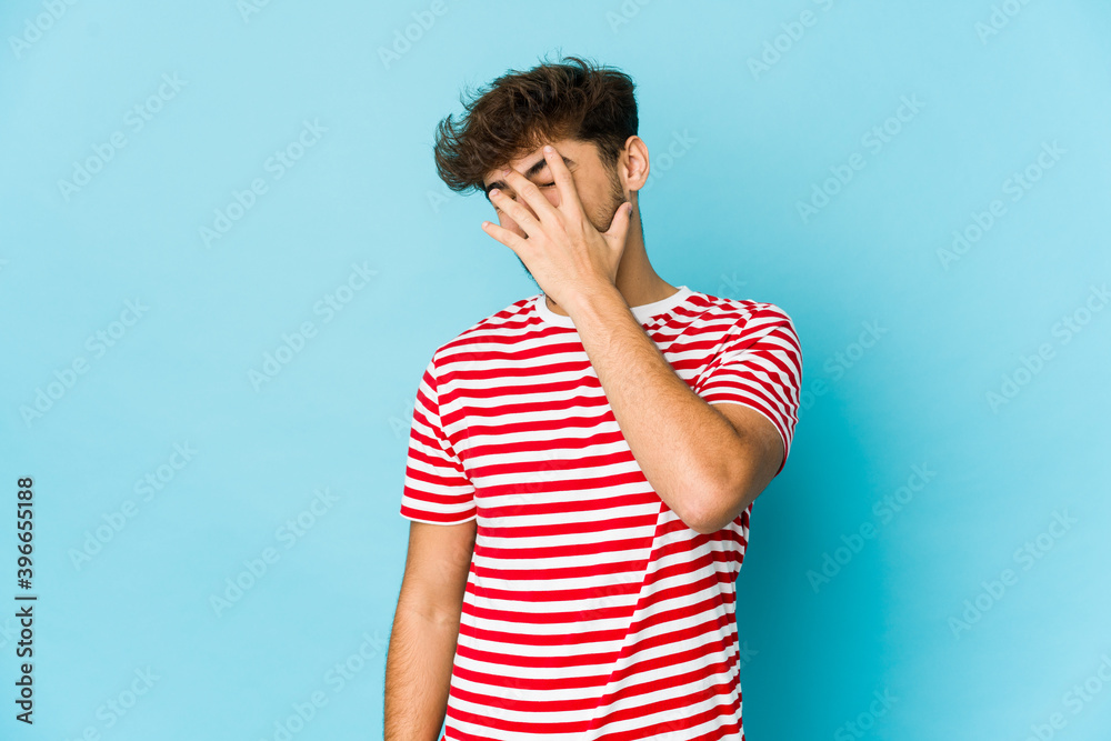 Young arab man on blue background laughing happy, carefree, natural emotion. Young arab man on blue background laughing happy, carefree, natural emotion.