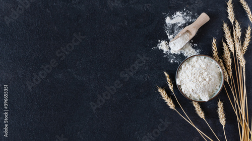Foto Bowl of wheat flour over black surface top view