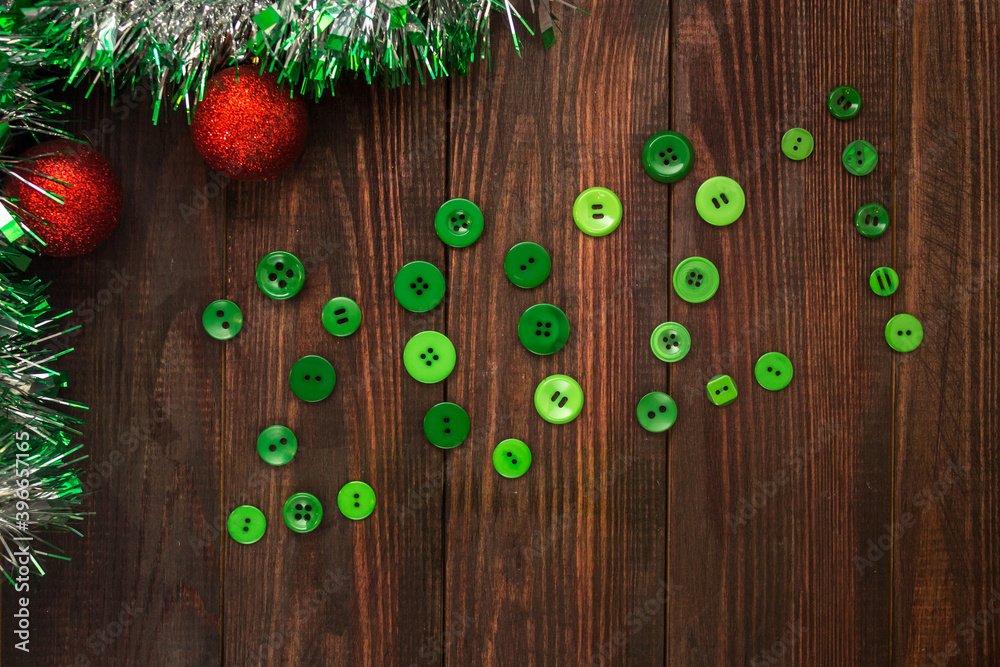wooden table with Christmas balls, garland and green buttons lined 2021 numbers. Flatlay wooden table with Christmas balls, garland and green buttons lined 2021 numbers. Flatlay