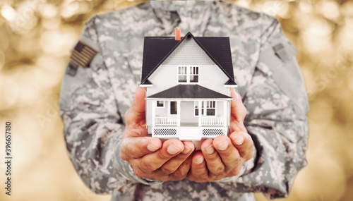 Foto Soldier man holding a model of house