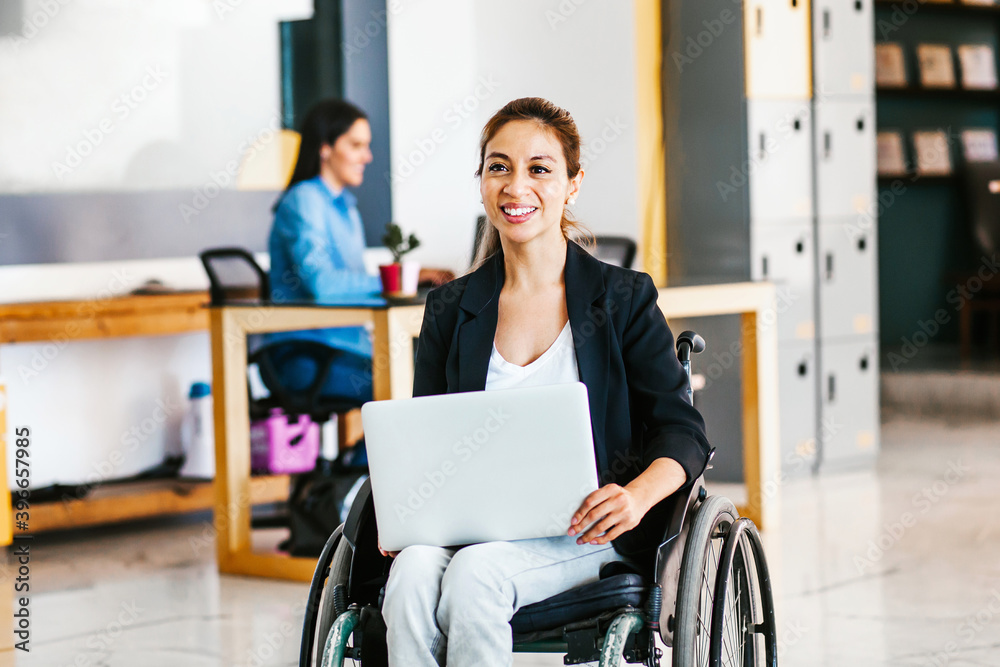 Mexican woman in wheelchair with her colleagues at workplace in Latin