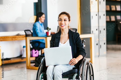Foto Mexican woman in wheelchair with her colleagues at workplace in Latin America