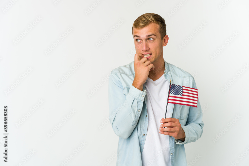 Young caucasian man holding a american flag isolated on white background Young caucasian man holding a american flag isolated on white background