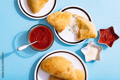 Overhead view of baked pizza puffs served with sauce on table photo