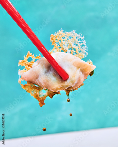 Close up of dumpling in chopsticks
