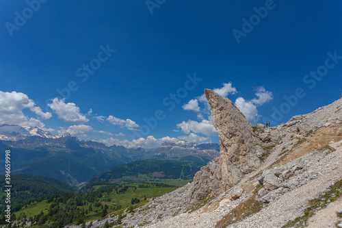 Bizarre shaped rocky peak near a hiking trail with awesome dolomite mountains background, Settsass, Dolomites, Italy