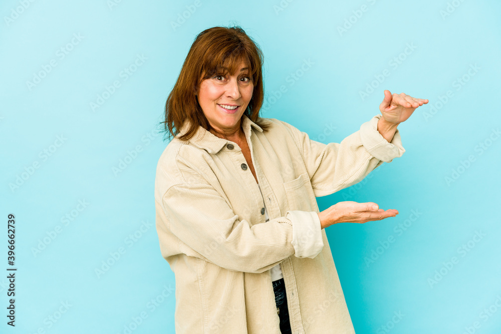 Senior caucasian woman isolated shocked and amazed holding a copy space between hands. Senior caucasian woman isolated shocked and amazed holding a copy space between hands.