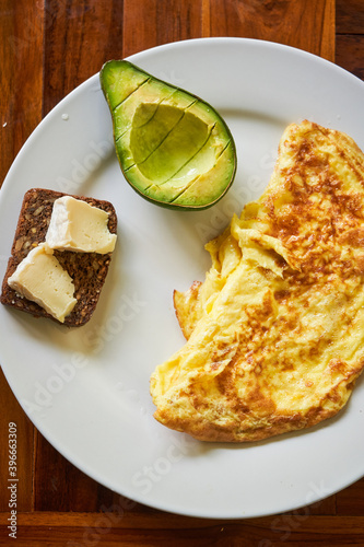 Breakfast dish with omet brown whole bread with cheese and avocado photo