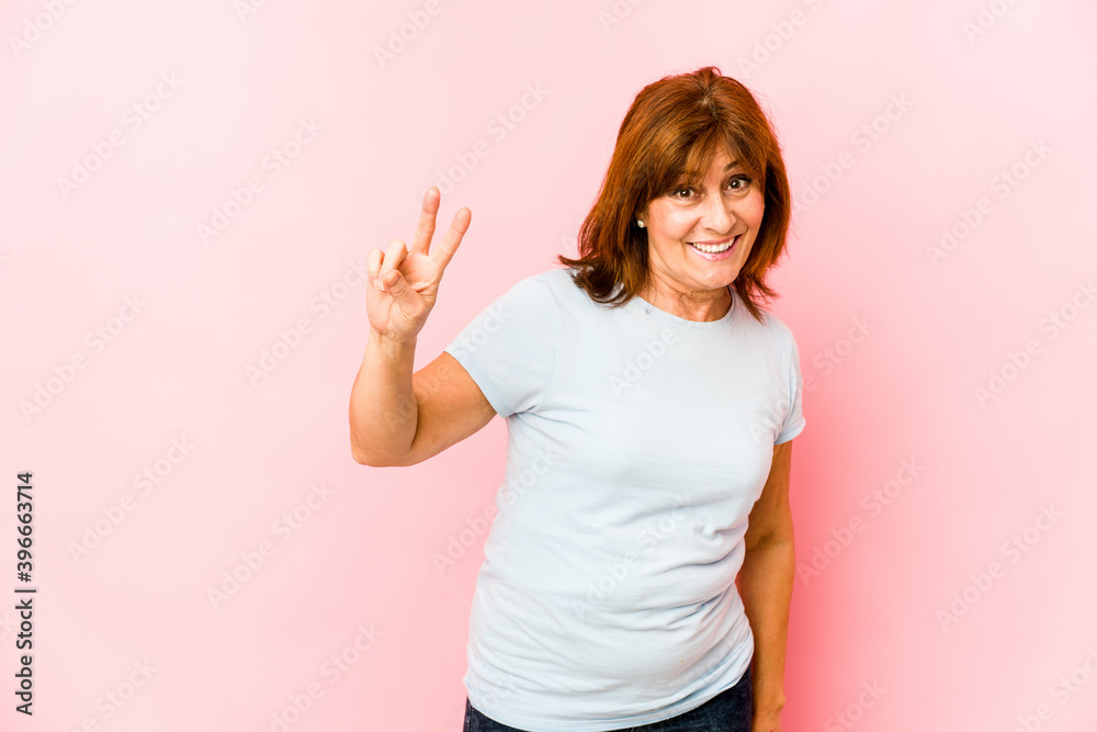Senior caucasian woman isolated joyful and carefree showing a peace symbol with fingers. Senior caucasian woman isolated joyful and carefree showing a peace symbol with fingers.