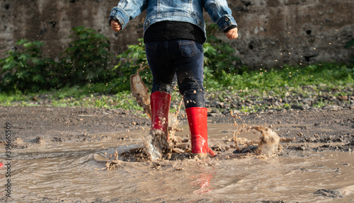 Foto Girl jumping in muddy puddles