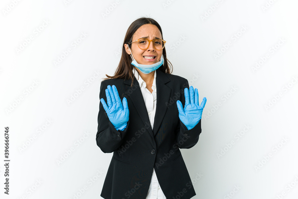 Young business latin woman wearing a mask to protect from covid isolated on white background rejecting someone showing a gesture of disgust. Young business latin woman wearing a mask to protect from covid isolated on white background rejecting someone showing a gesture of disgust.