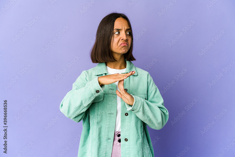 Young mixed race woman showing a timeout gesture. Young mixed race woman showing a timeout gesture.
