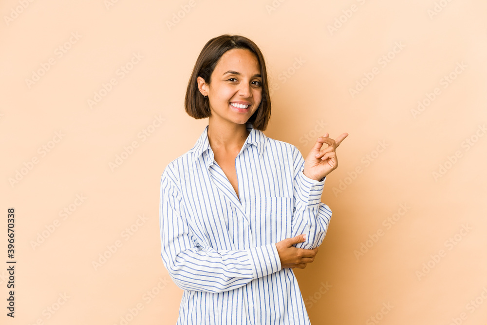Young hispanic woman isolated smiling cheerfully pointing with forefinger away. Young hispanic woman isolated smiling cheerfully pointing with forefinger away.