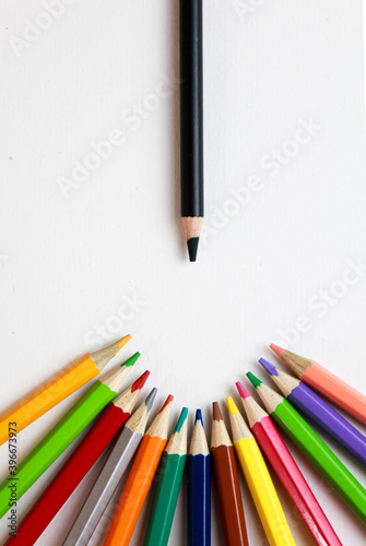 colored pencils and black pencil on a white background