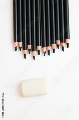 black pencils on a white background with an elastic band
