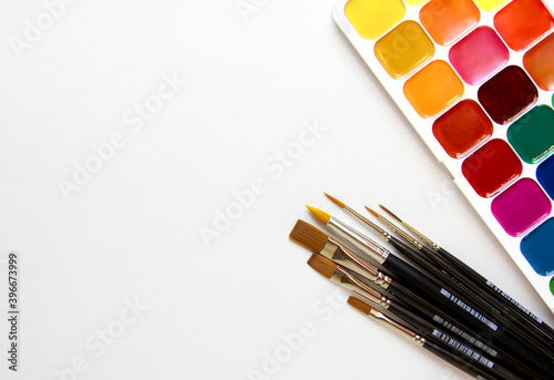 watercolor paints palette and brushes  on a white background