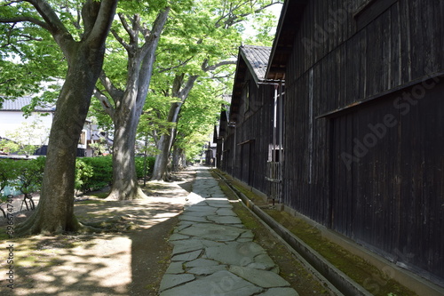 山居倉庫（さんきょそうこ）／ 日本有数の米どころ、山形県庄内のシンボル「山居倉庫」は、明治26年(1893)に建てられ、現在も現役の米保管倉庫です。白壁、土蔵づくり９棟からなる倉庫の米の収容能力は10,800トン(18万俵)です。夏の高温防止のために背後にケヤキ並木を配し、内部の湿気防止には二重屋根にするなど、自然を利用した先人の知恵が生かされた低温倉庫です。