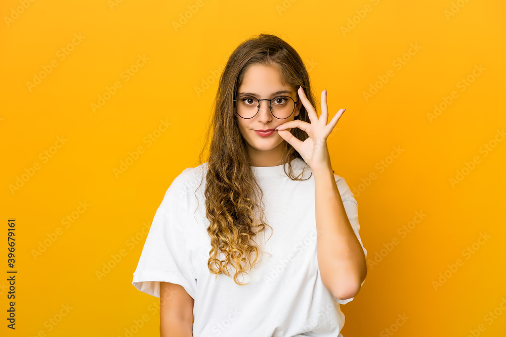 Young caucasian woman with fingers on lips keeping a secret. Young caucasian woman with fingers on lips keeping a secret.