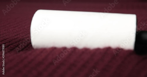 Close up macro view of a sticky depilling fabric roller on a maroon sweater photo