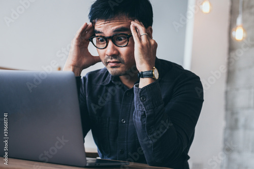 sad depression serious people from work stress concept.asian man feeling tired suffering using computer working work place.concept global economic and health problems