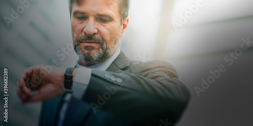 Businessman checking his watch while rushing to work