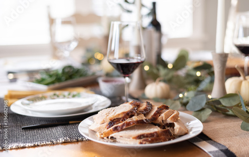 Plate of sliced turkey with red wine in blurred background