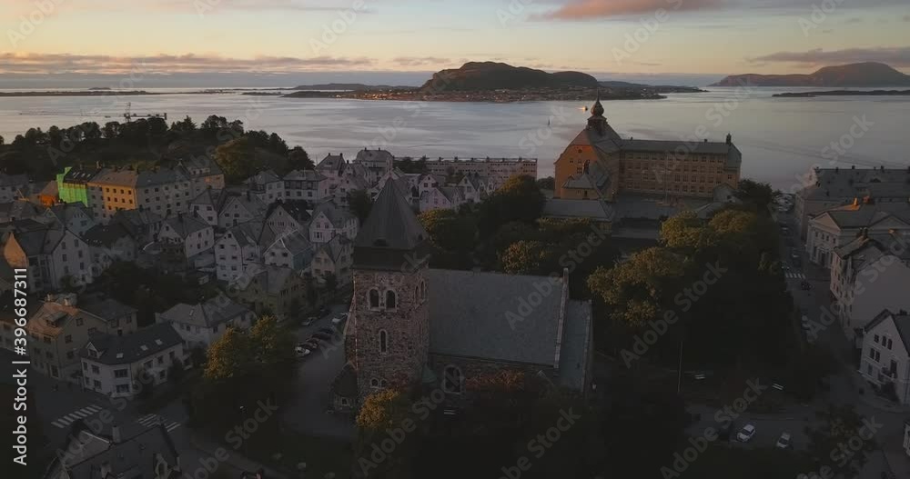 Slowly ascending, picturesque aerial time lapse that circles around the church of Alesund & revealing the sea, islands, mountains & cityscape of Alesund, the most beautiful town in Norway at sunset. Slowly ascending, picturesque aerial time lapse that circles around the church of Alesund & revealing the sea, islands, mountains & cityscape of Alesund, the most beautiful town in Norway at sunset.