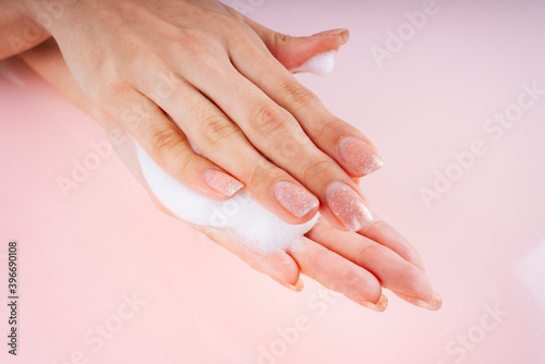 Woman hands with lotion foam.
