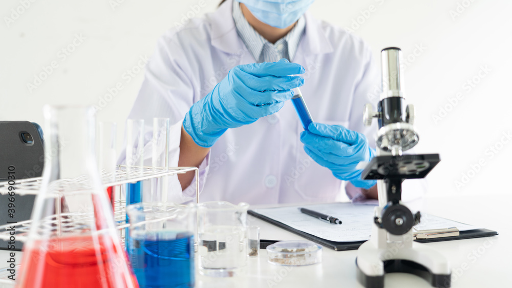 Young Asian scientist Working looking through a microscope doing research for analyzing a Experiments sample in a forensic laboratory. Young Asian scientist Working looking through a microscope doing research for analyzing a Experiments sample in a forensic laboratory.