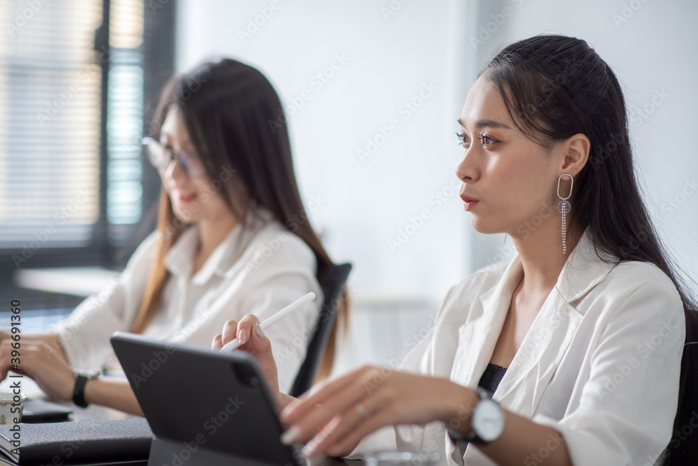 Young asian business woman meeting to work and using digital tablet with their colleagues in the office. Young asian business woman meeting to work and using digital tablet with their colleagues in the office.