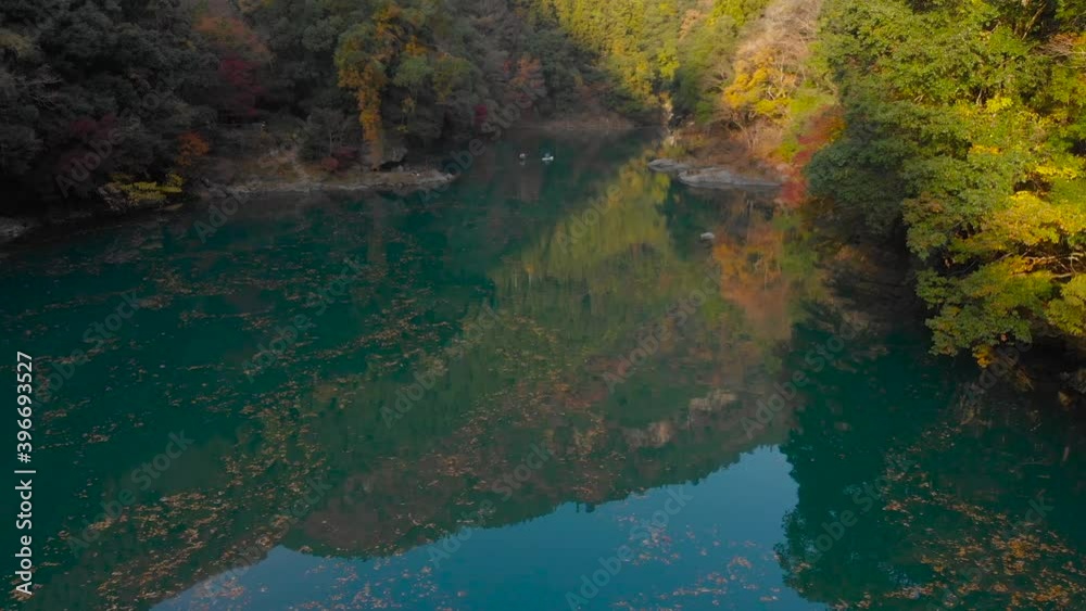 Slow cinematic tilt down towards water reflections in pristine nature with Kayak in distance
