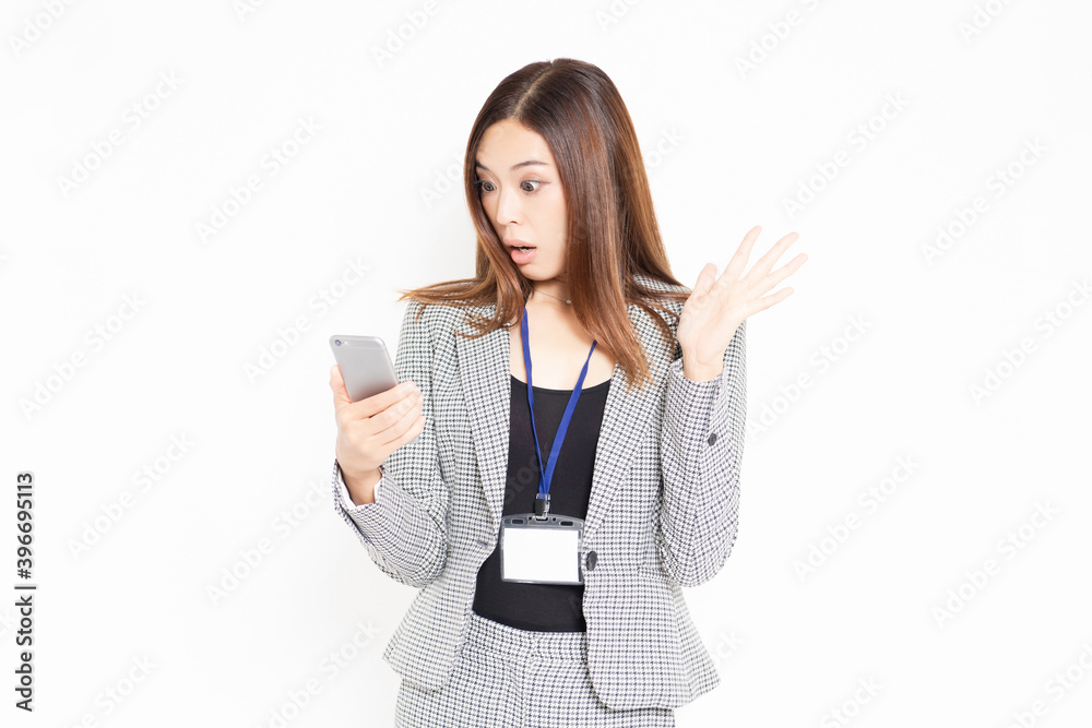 スマホを使いながら驚いているビジネスウーマン スマホを使いながら驚いているビジネスウーマン