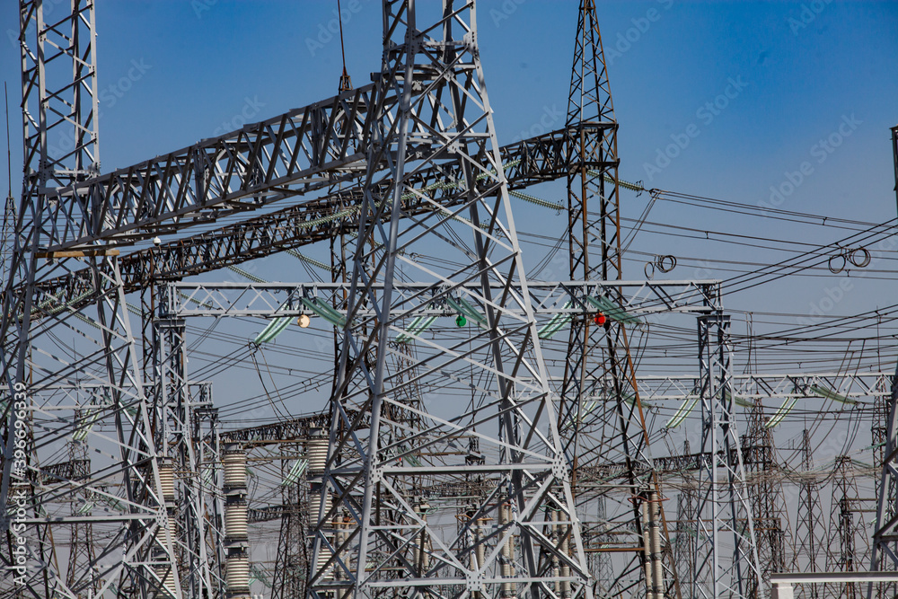 Close-up view of electric transformer substation. Distribution station of electricity. Blue sky background. Close-up view of electric transformer substation. Distribution station of electricity. Blue sky background.