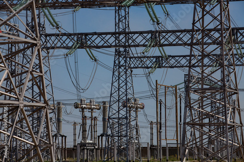 Electric pylons and wires. Distributing substation close-up. Blue sky background.