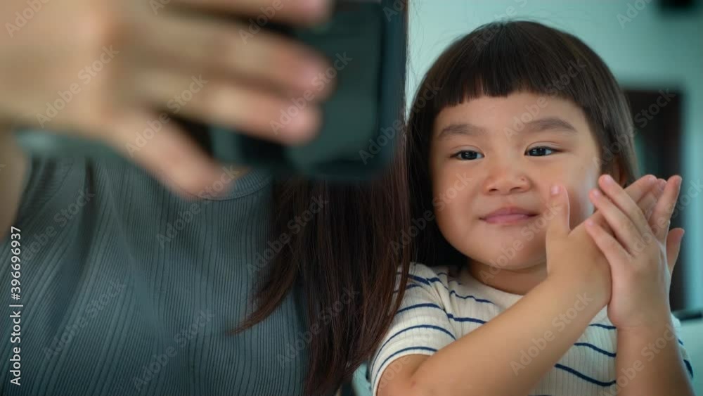 Family and technology concept, Asian happy Mother and daughter having fun while using App on smartphone and taking or video call with Father. Family and technology concept, Asian happy Mother and daughter having fun while using App on smartphone and taking or video call with Father.