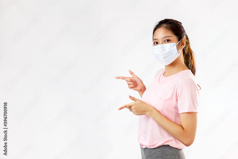 Asian woman with mask in sport dress pointing finger on white background
Asian woman with mask in sport dress pointing finger on white background