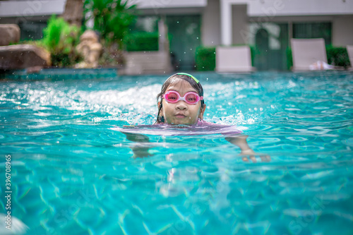 Close-up background angle Of Asian girls playing in the water or practicing swimming in the pool during summer vacation