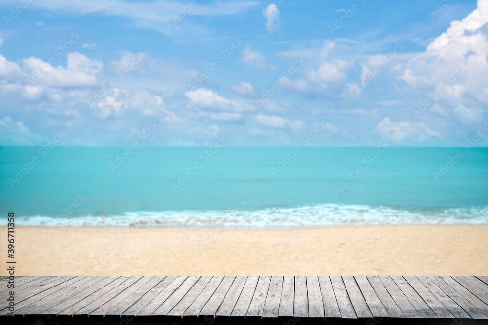 Fototapeta premium Close up wooden table top on sandy beach blue sea and tropical beach , Summer holiday concept.