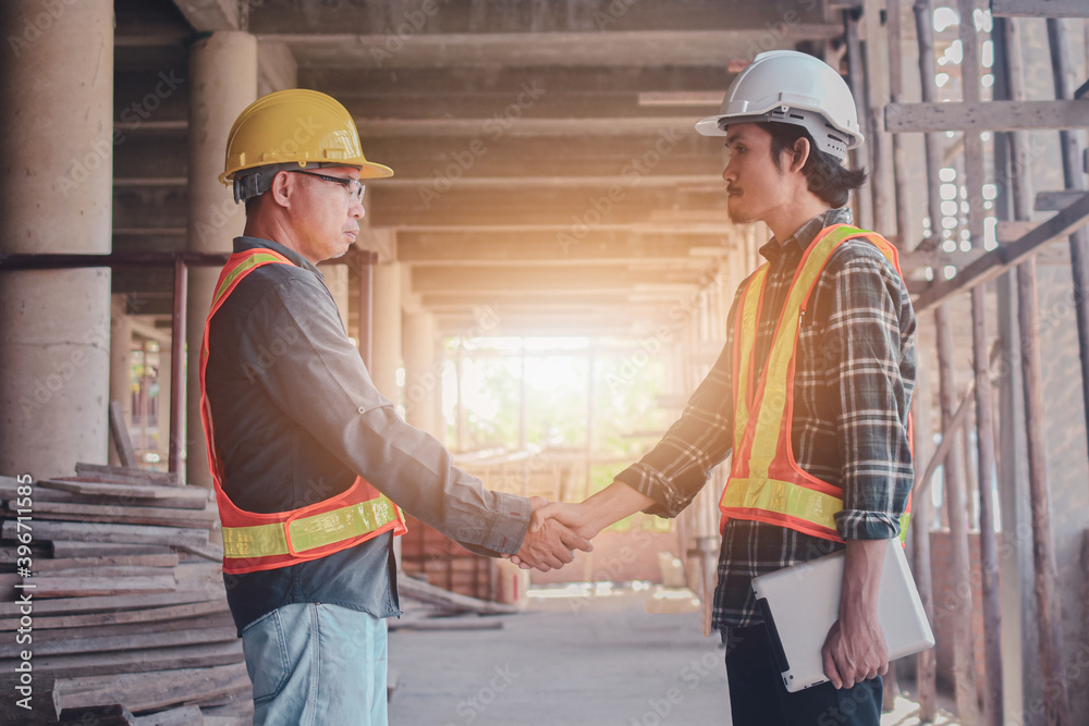 Two people engineer shake hand on site construction indoor Two people engineer shake hand on site construction indoor