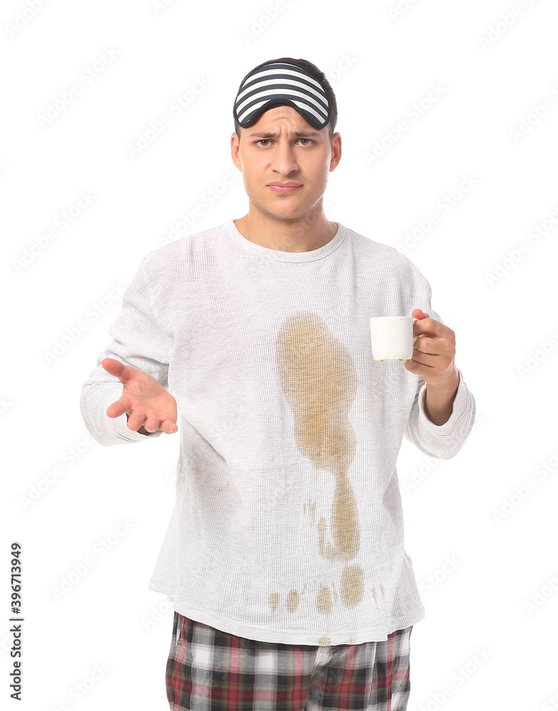 Stressed young man with coffee stains on his pajama top on white background Stressed young man with coffee stains on his pajama top on white background