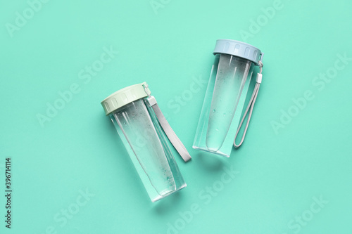 Bottles of water on color background