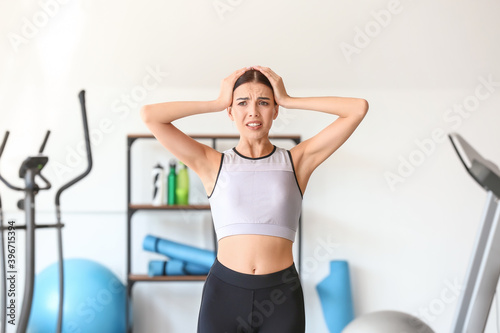 Stressed young woman in gym