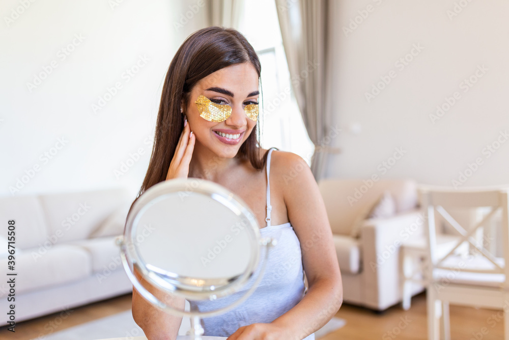 Beauty portrait of young woman with wrinkles and a golden patch under eyes. Collagen mask and spa concept. Copy space. Summer skin care. Looking in the mirror Beauty portrait of young woman with wrinkles and a golden patch under eyes. Collagen mask and spa concept. Copy space. Summer skin care. Looking in the mirror