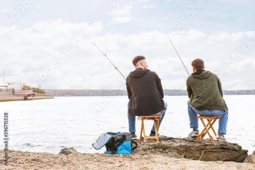 Young men fishing on river