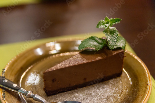 Piece of chocolate cheesecake with berries on dark background, close up photo