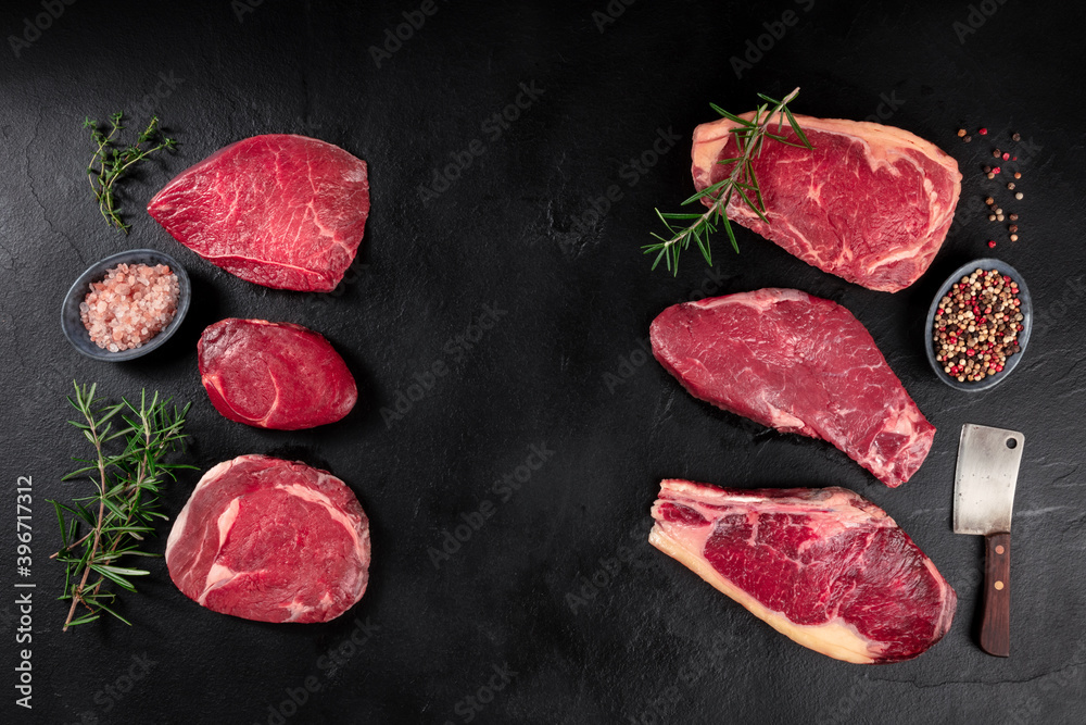 Meat, different cuts, shot from the top on a dark background with condiments and a place for text Meat, different cuts, shot from the top on a dark background with condiments and a place for text